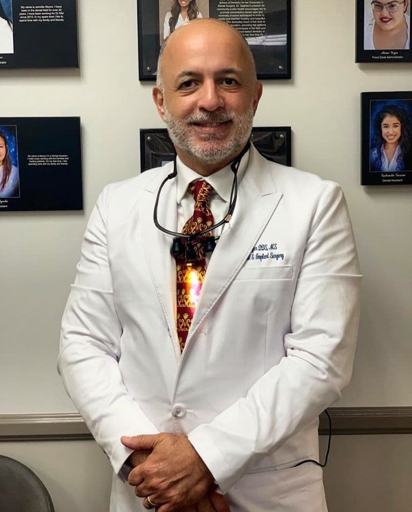 Dr. Bijan Afar, DDS, in his white coat with surgical loupes at the Allure Dental Arts office